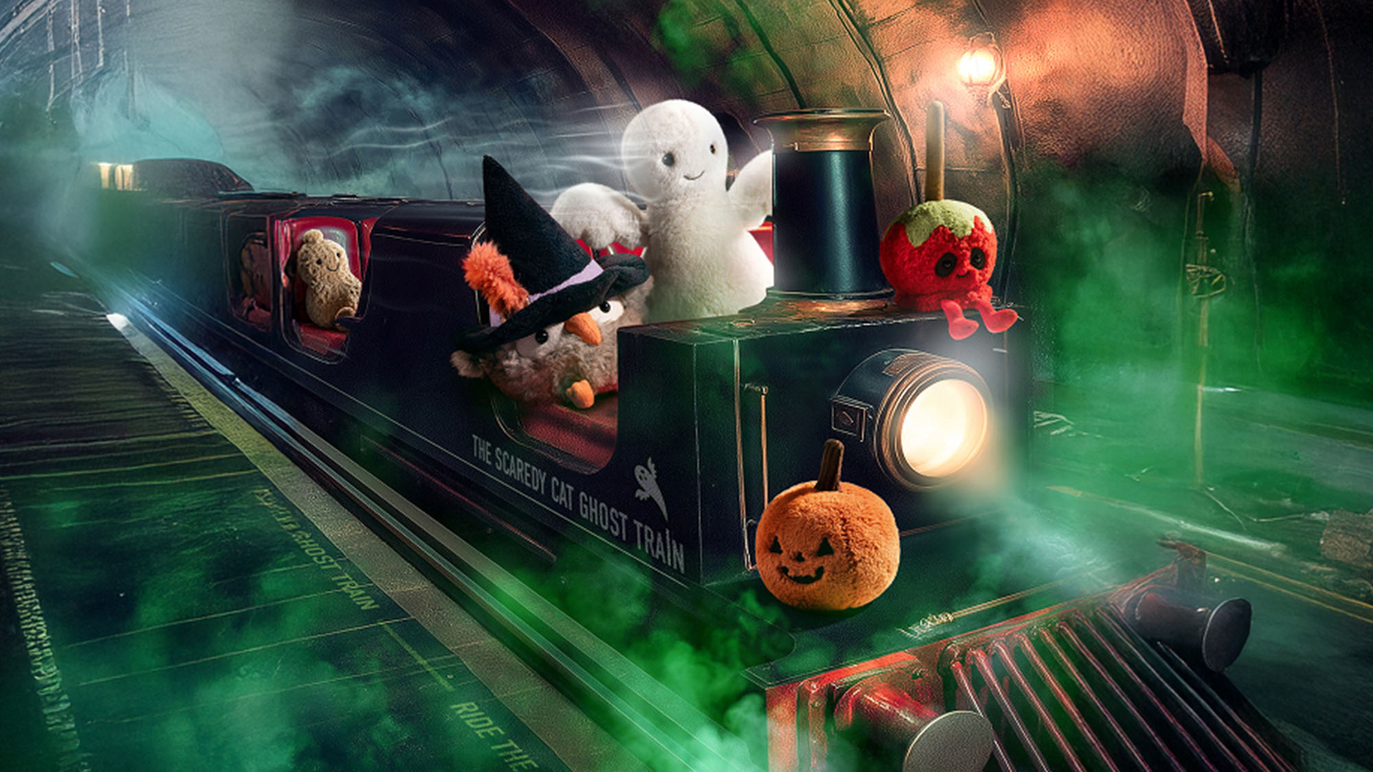 Plush toys on a Halloween-themed ghost train in a misty tunnel.