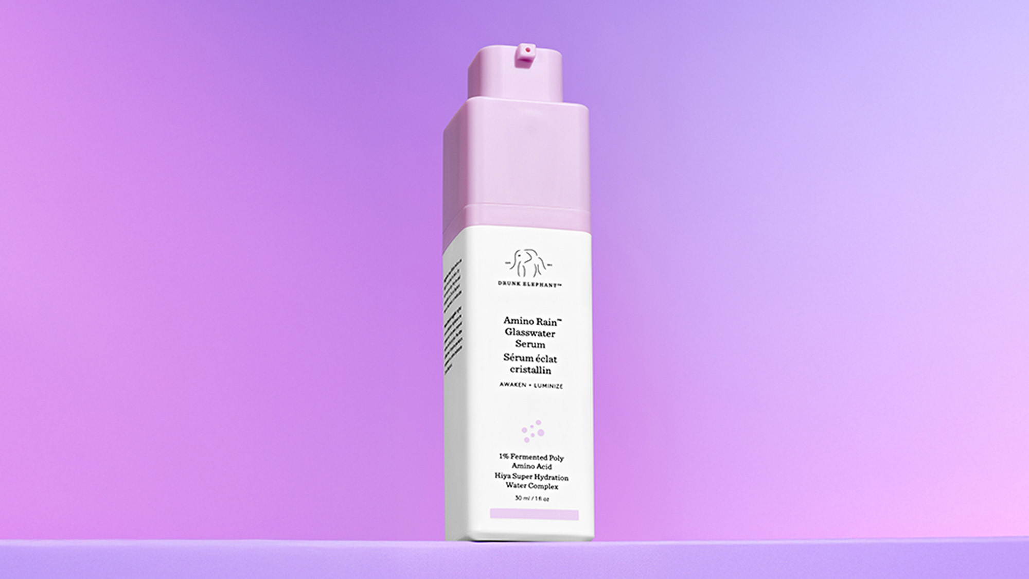 A skincare product with a pink cap and white bottle is displayed against a gradient purple background.