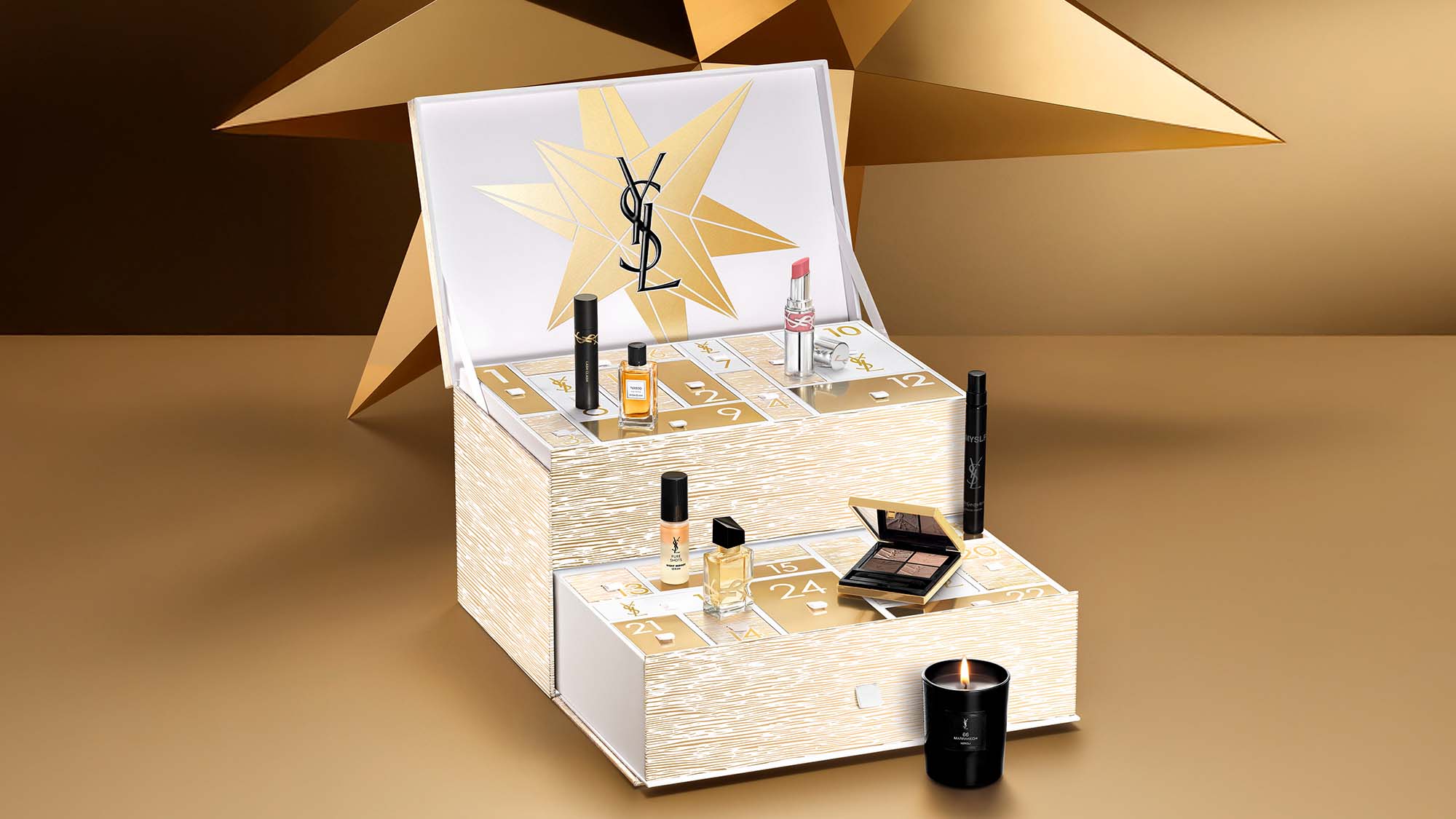 A luxury advent calendar with beauty products, featuring gold and white design, displayed with a candle.