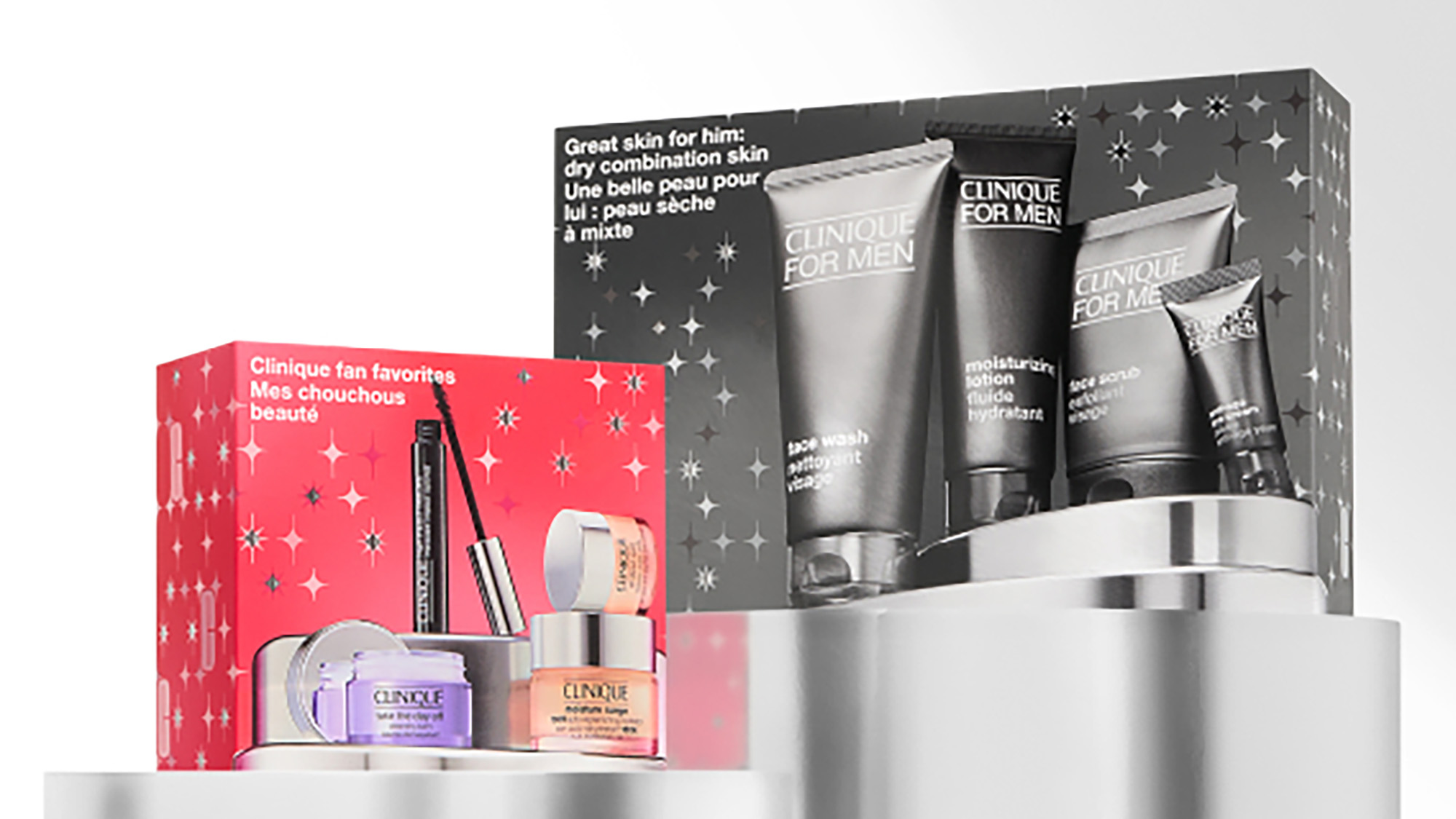 Two Clinique gift sets on a display: one for women in a red box, and one for men in a black box, both showcasing skincare products.