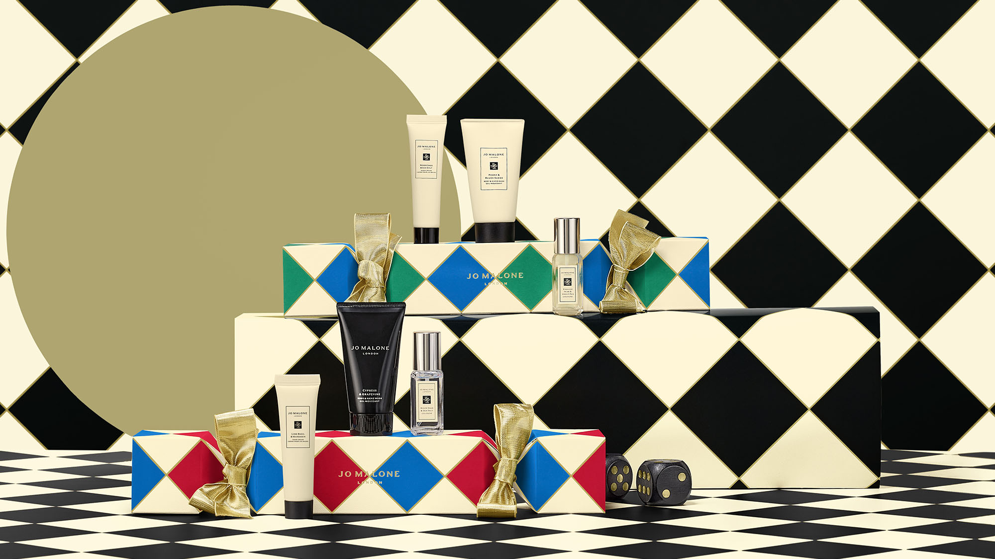 Jo Malone London products displayed on colorful boxes with a checkered background, featuring lotions and perfumes.