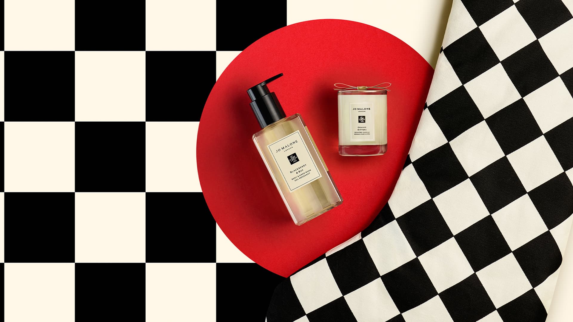 Jo Malone London products with a black and white checkered stocking on a red circle background.