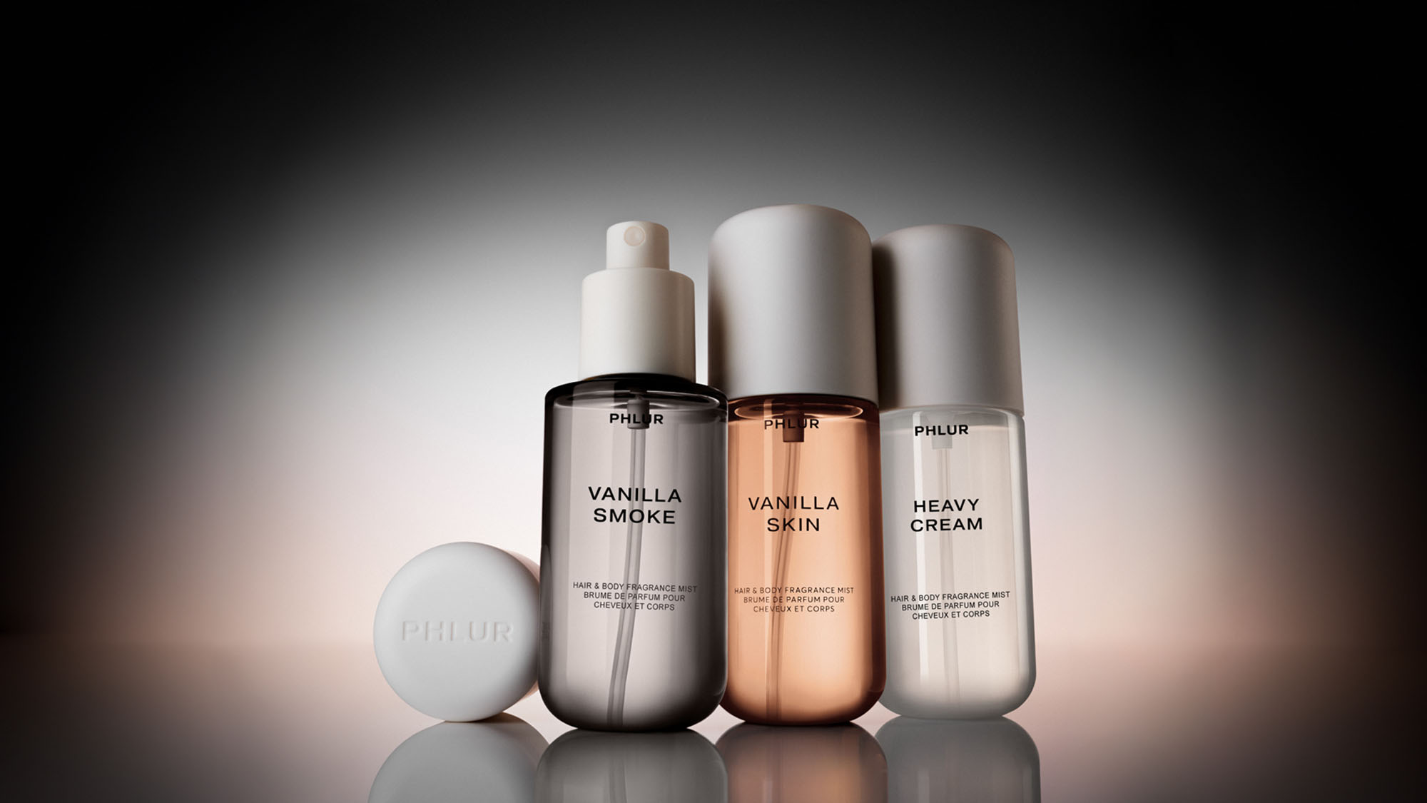 Three cosmetic bottles labeled 'Vanilla Smoke,' 'Vanilla Skin,' and 'Heavy Cream' with a small round cap on the side.