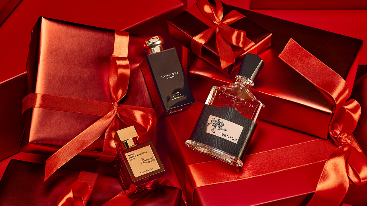 Perfume bottles surrounded by red gift boxes and red ribbons.
