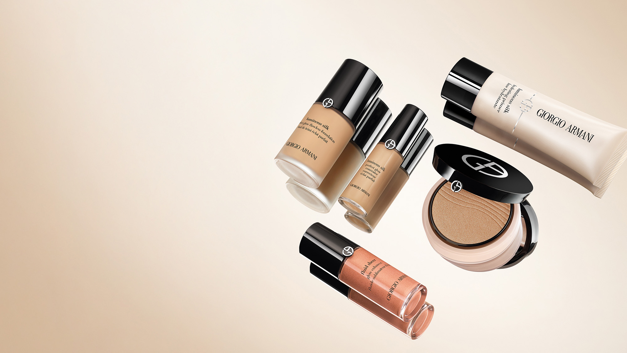 A collection of Giorgio Armani makeup products, including foundations, a compact, a tube, and a liquid bottle, on a beige background.
