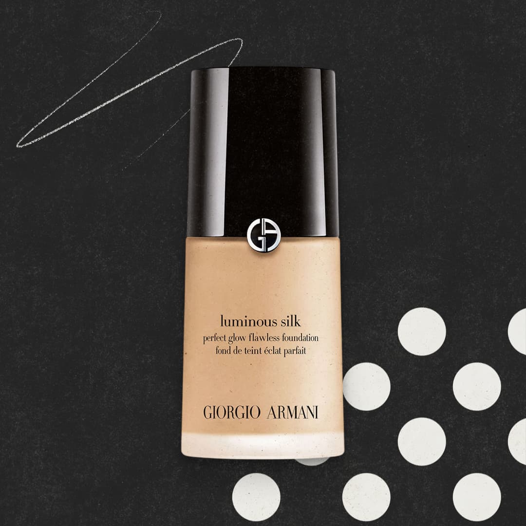 A bottle of Giorgio Armani Luminous Silk foundation on a dark background with white circles and lines.