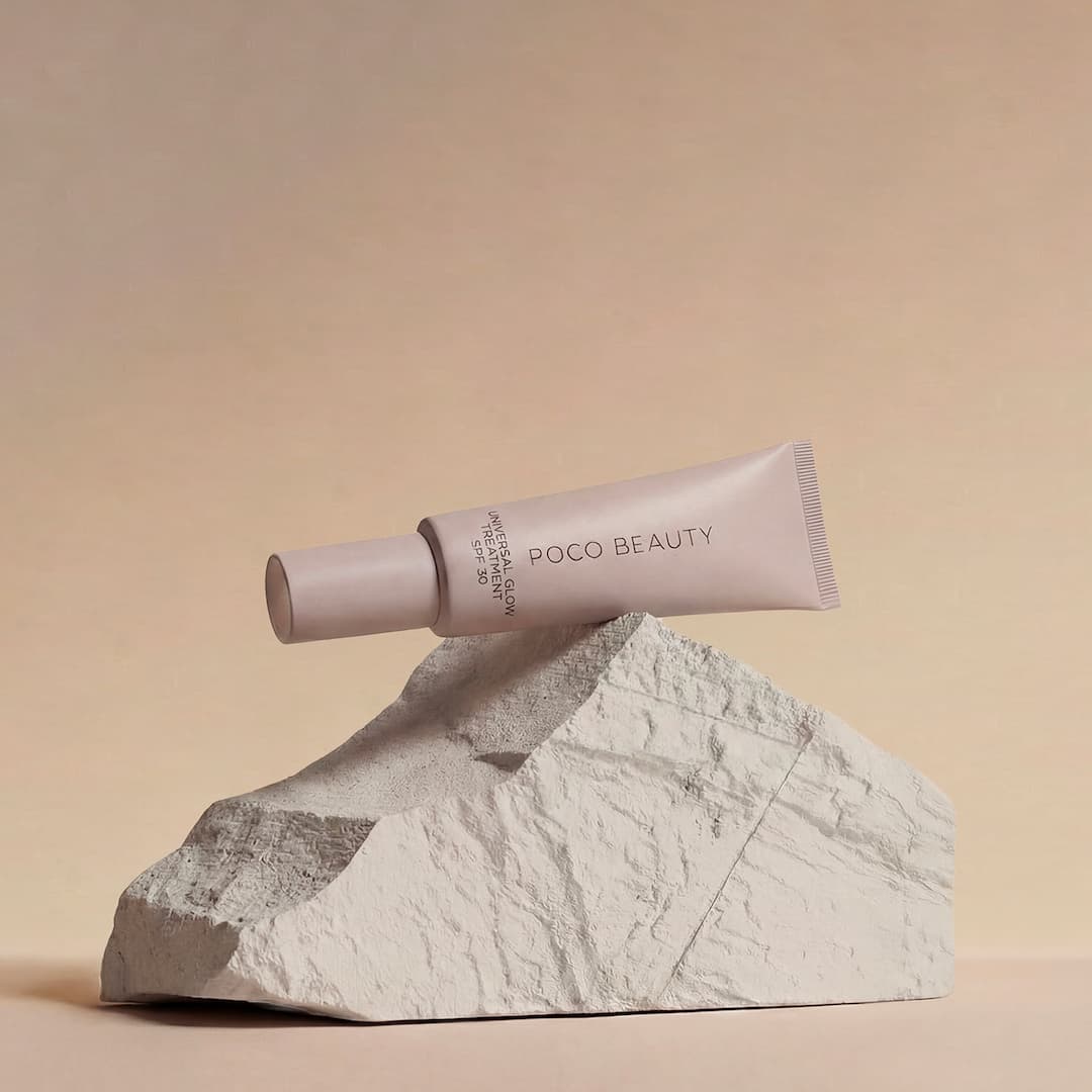 A minimalist, pastel-colored tube labeled 'Poco Beauty' rests atop a textured rock against a neutral background.