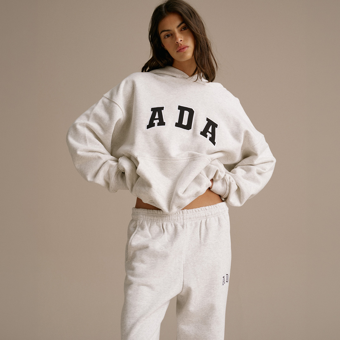 Woman wearing cream sweatshirt and matching joggers with ADA text print