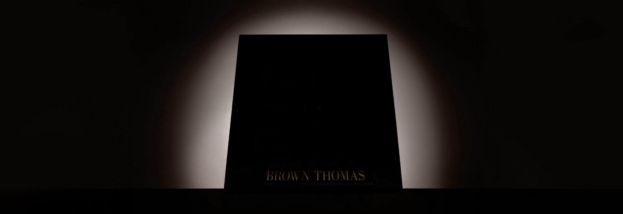 A dark rectangular object is silhouetted against a softly glowing background.