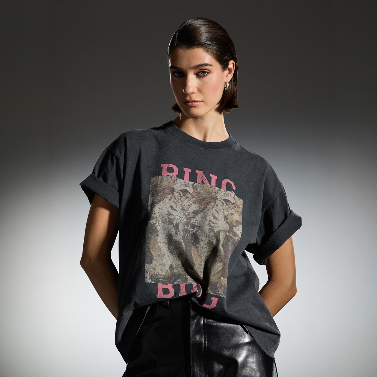Woman wearing black graphic t-shirt with text design and black leather skirt