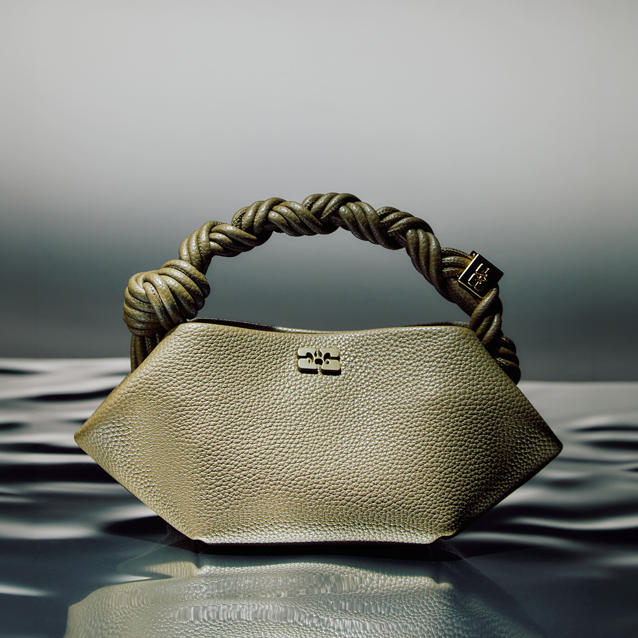 Cream textured handbag with twisted gold rope handles and metal clasp detail