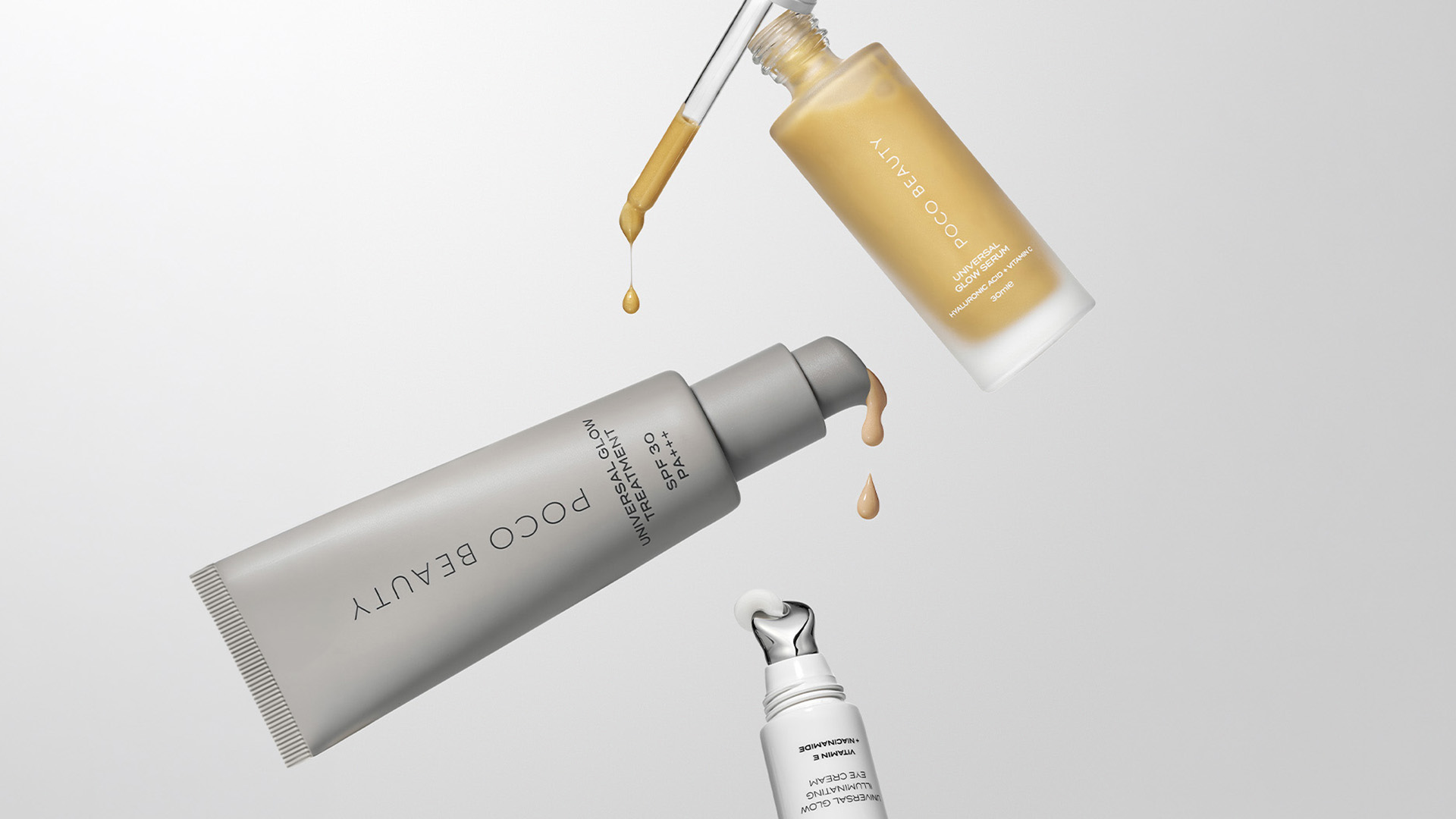 Three skincare products, one with a dropper and two in tubes, floating with droplets against a light gray background.
