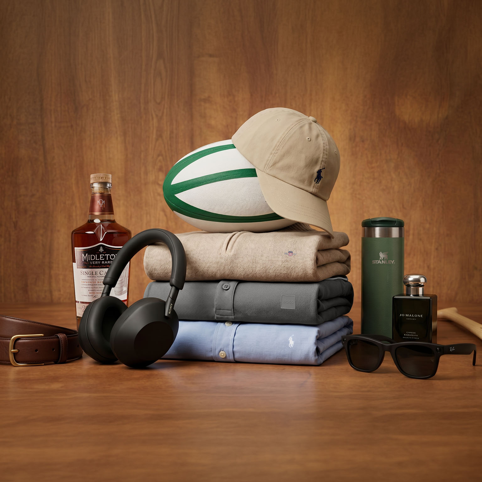 Father's Day gift collection including whisky, headphones, clothing, rugby ball, sunglasses and cologne