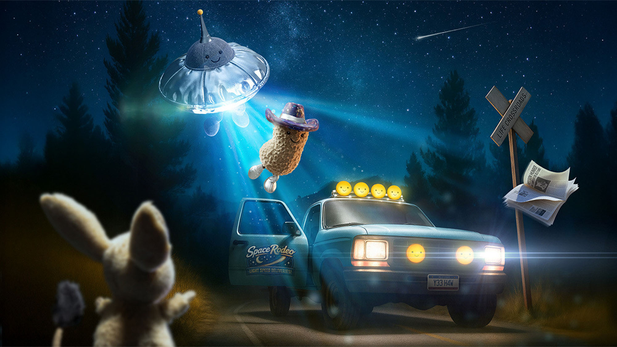Whimsical nighttime scene with plush Jellycat space toys including an alien in a flying saucer, smiling character in cowboy hat, and toy car with yellow planet lights on a moonlit forest road