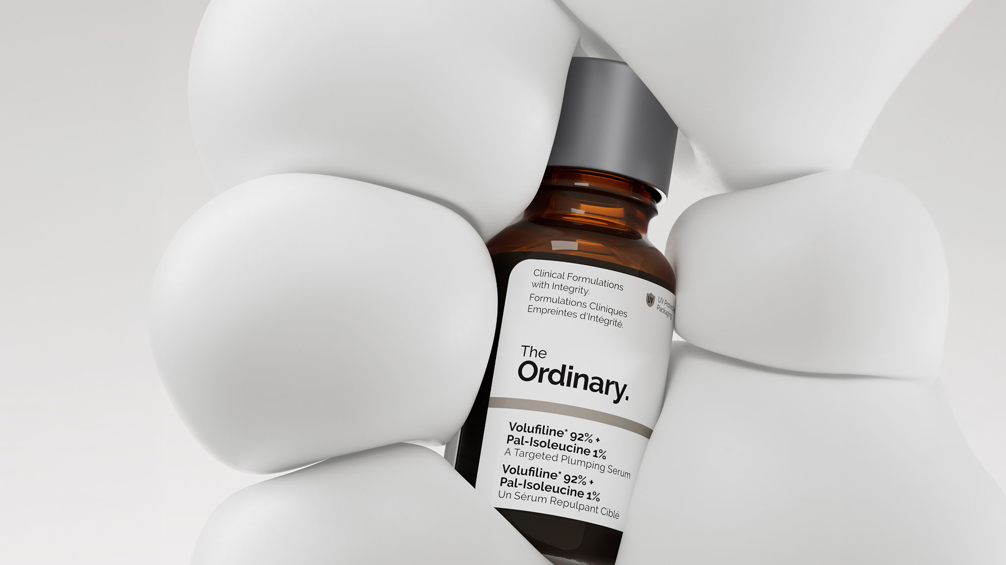 A bottle of The Ordinary skincare serum is encased within smooth, white sculptural shapes.
