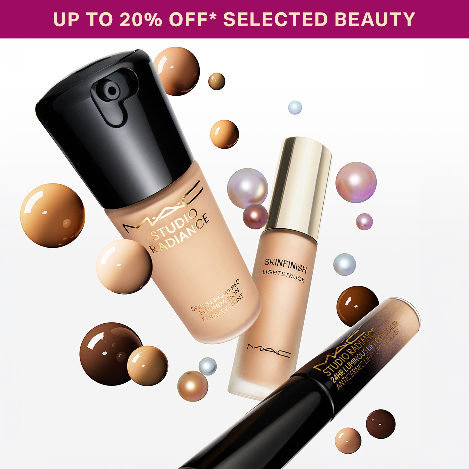 MAC Studio Radiance and Skinfinish makeup products with Strobe Cream, displayed with bronze and iridescent decorative spheres