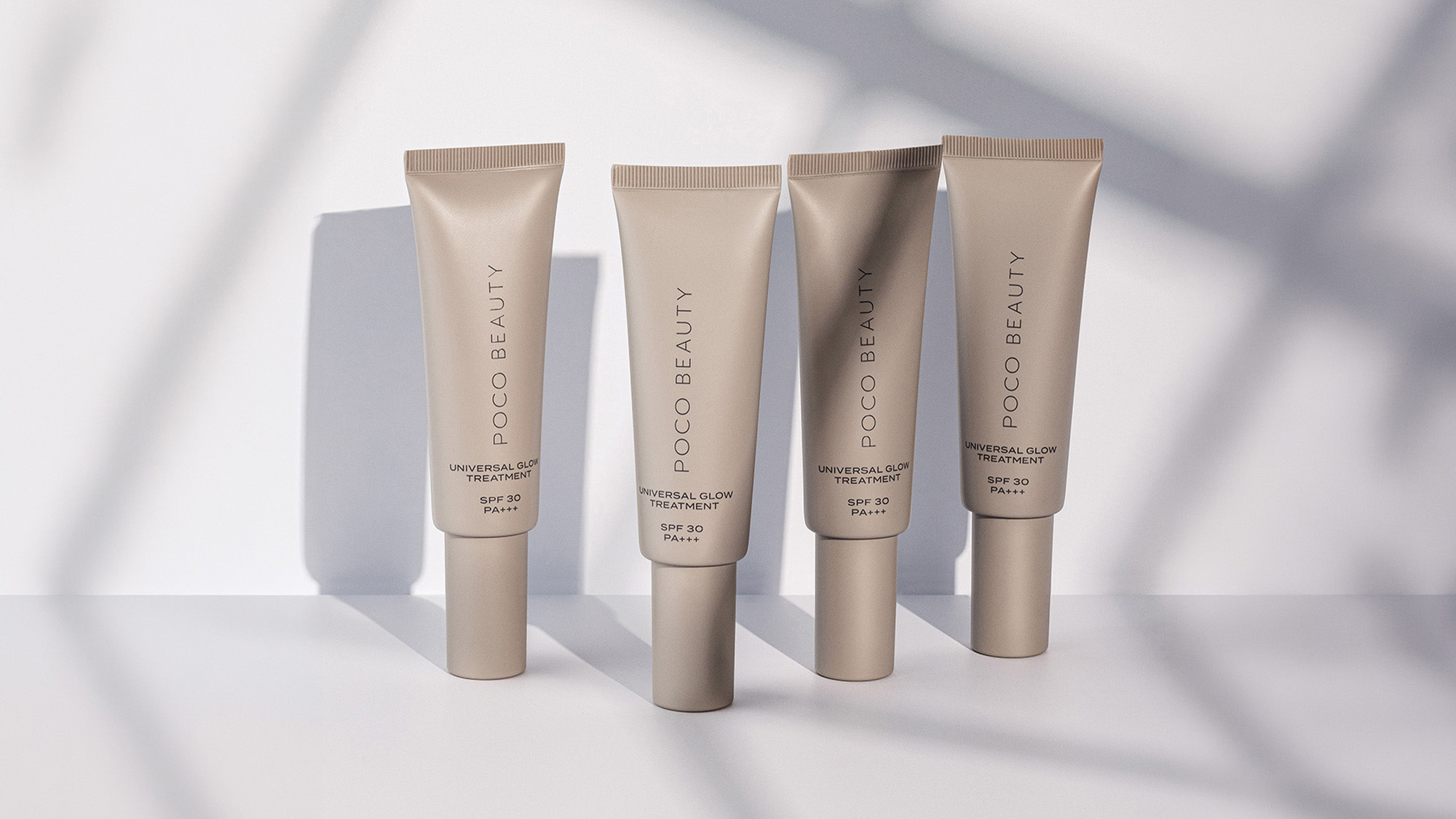 Four tubes of Poco Beauty Universal Glow Treatment SPF 30 displayed on white surface with soft shadows