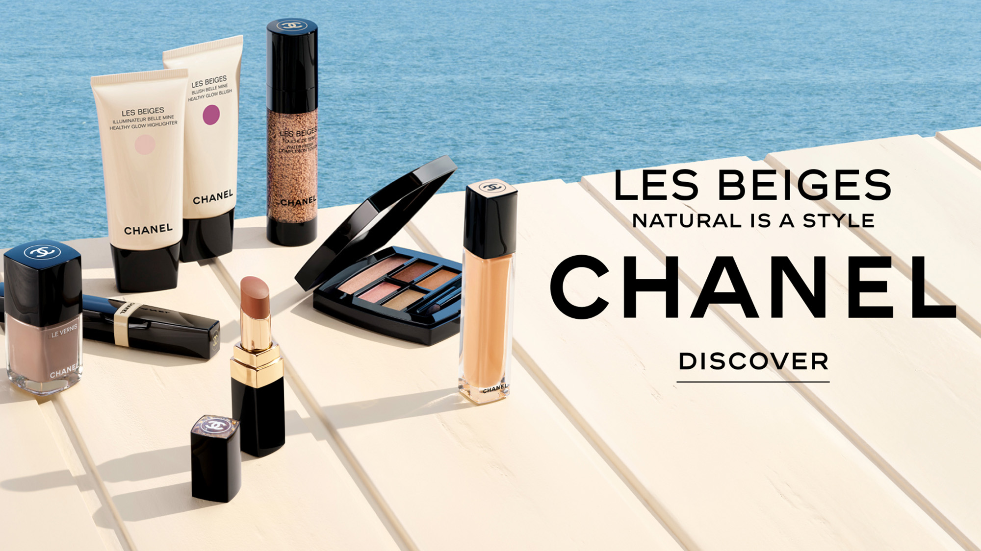 Chanel cosmetics on a beige surface beside a pool, with the text 'Les Beiges Natural is a Style CHANEL Discover.'