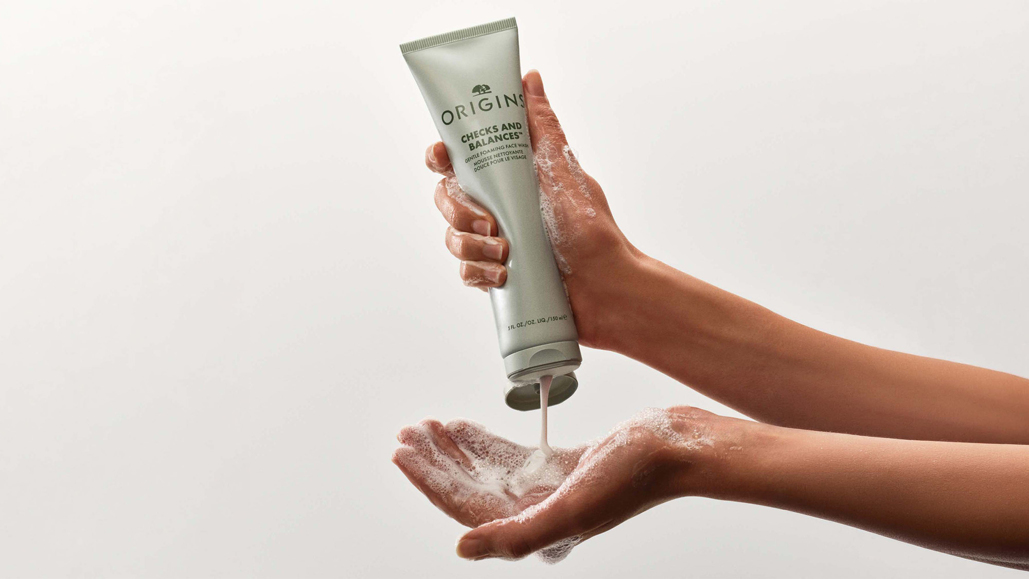 Origins Checks and Balances face wash being dispensed onto hands for cleansing