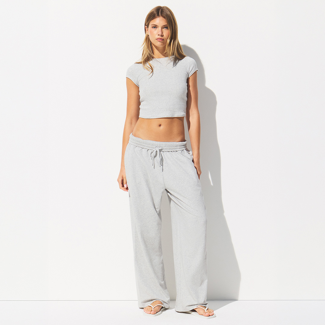Woman wearing grey cropped t-shirt and matching wide-leg joggers