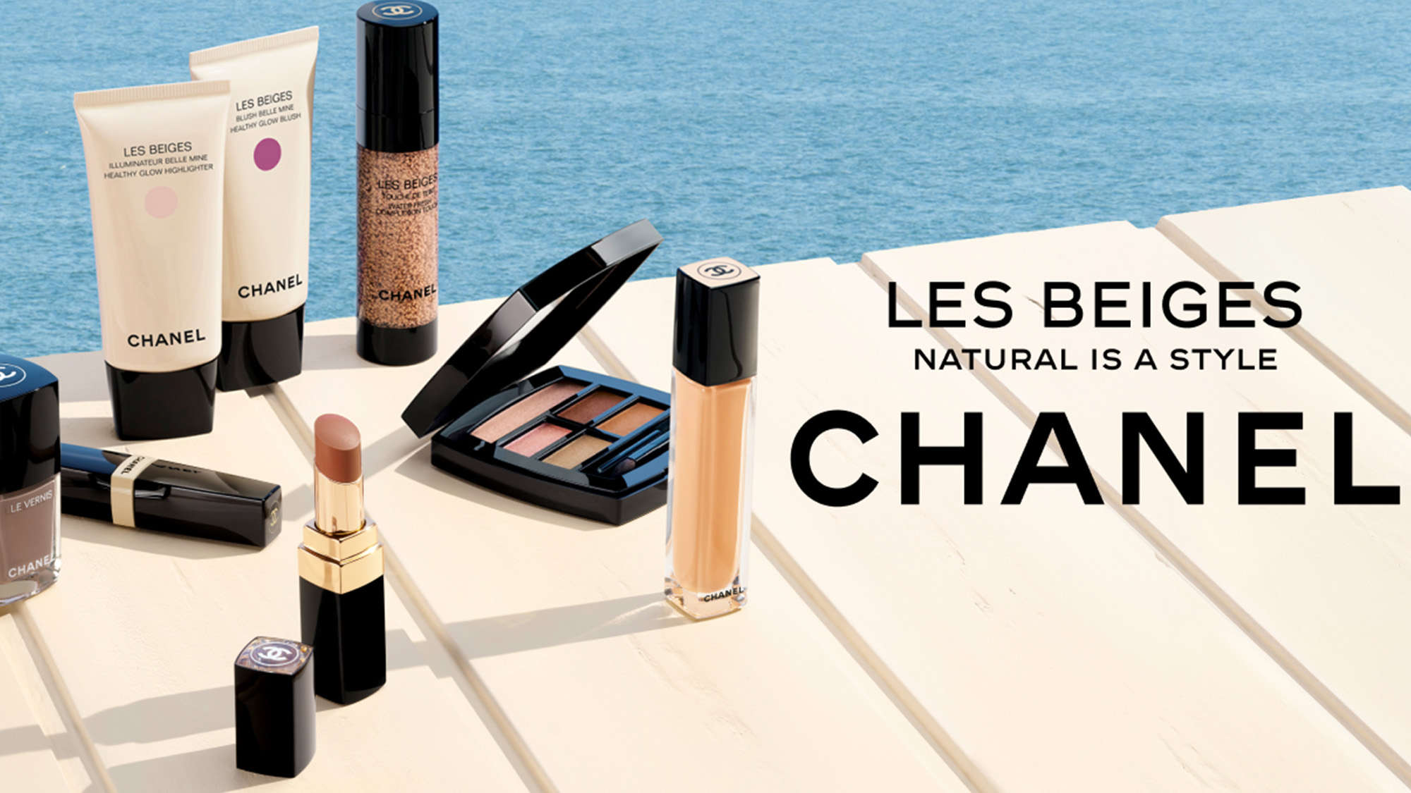Chanel Les Beiges collection displayed poolside, including illuminating gel, highlighter, lipstick, eyeshadow palette and foundation
