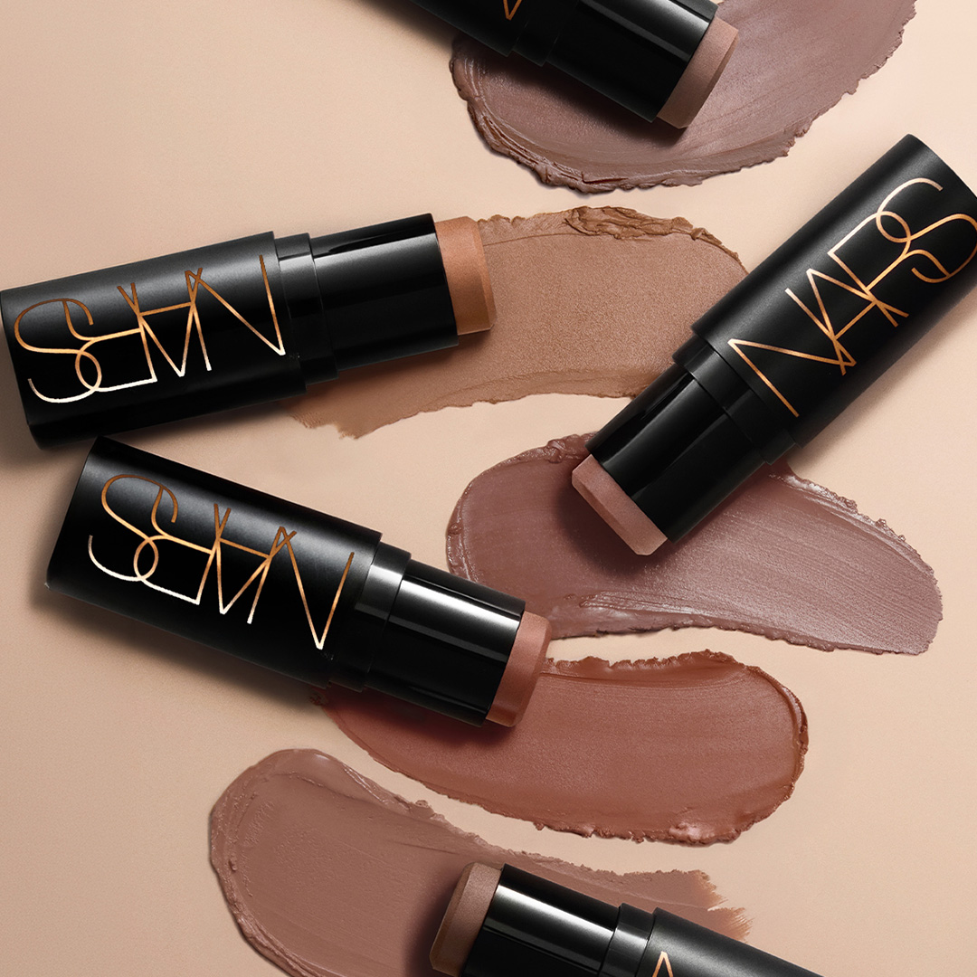 NARS foundation sticks in neutral tones with swatched colour samples on beige background