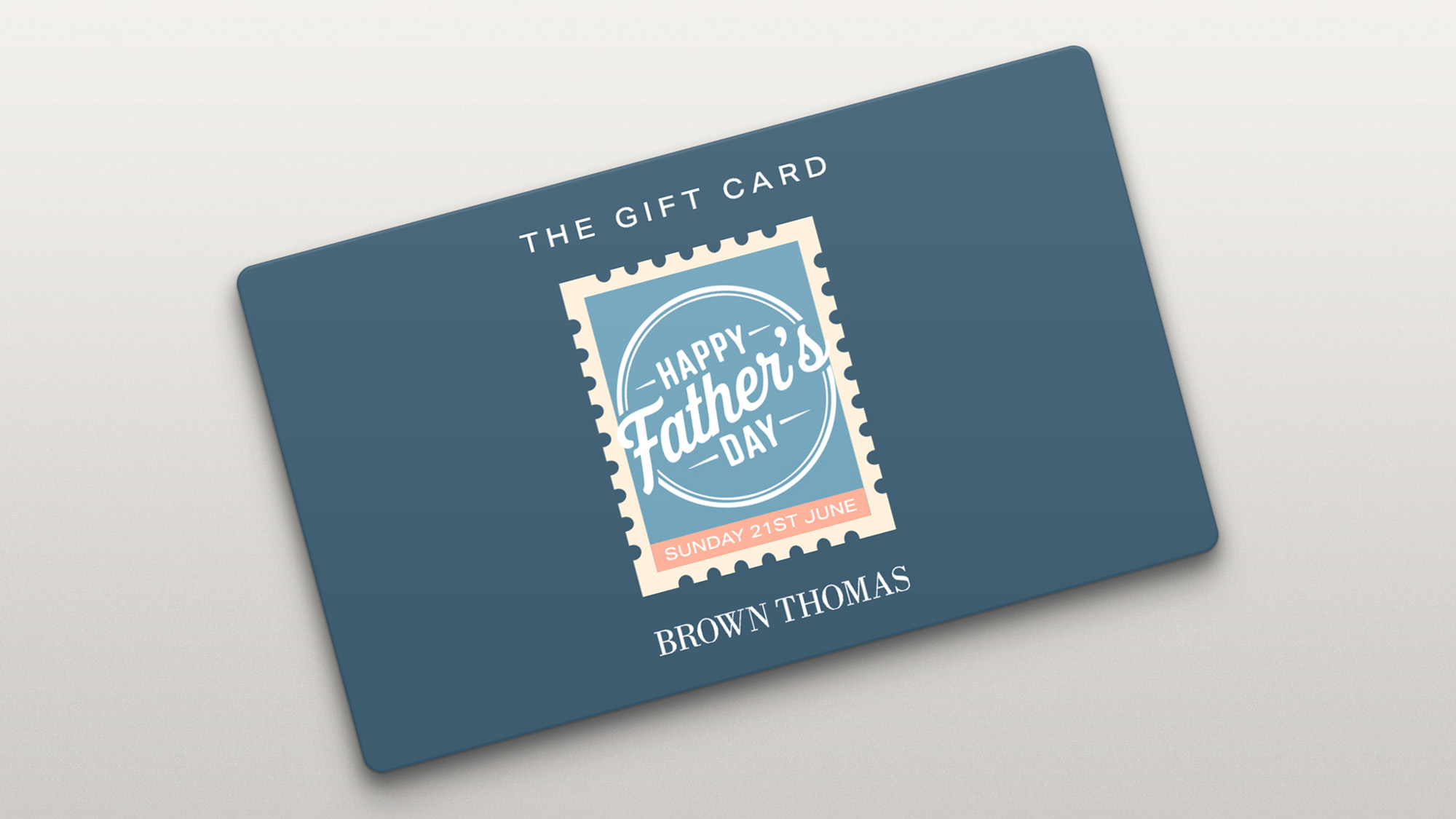 Blue gift card with Happy Father's Day stamp design and Sunday 21st June date. Brown Thomas branding.