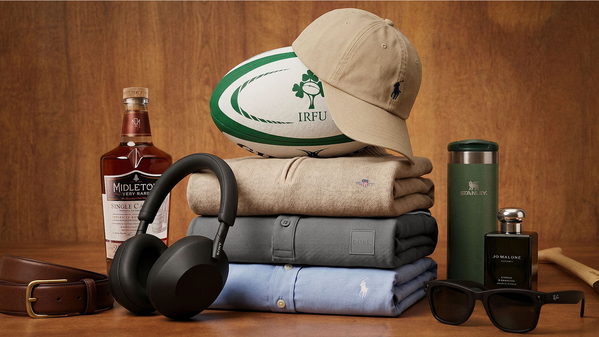 Father's Day gift collection including whisky, headphones, clothing, rugby ball, sunglasses and cologne