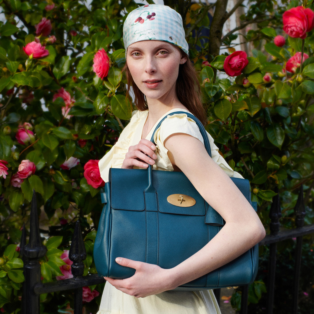 Woman in polka dot outfit holding colourful Mulberry handbag