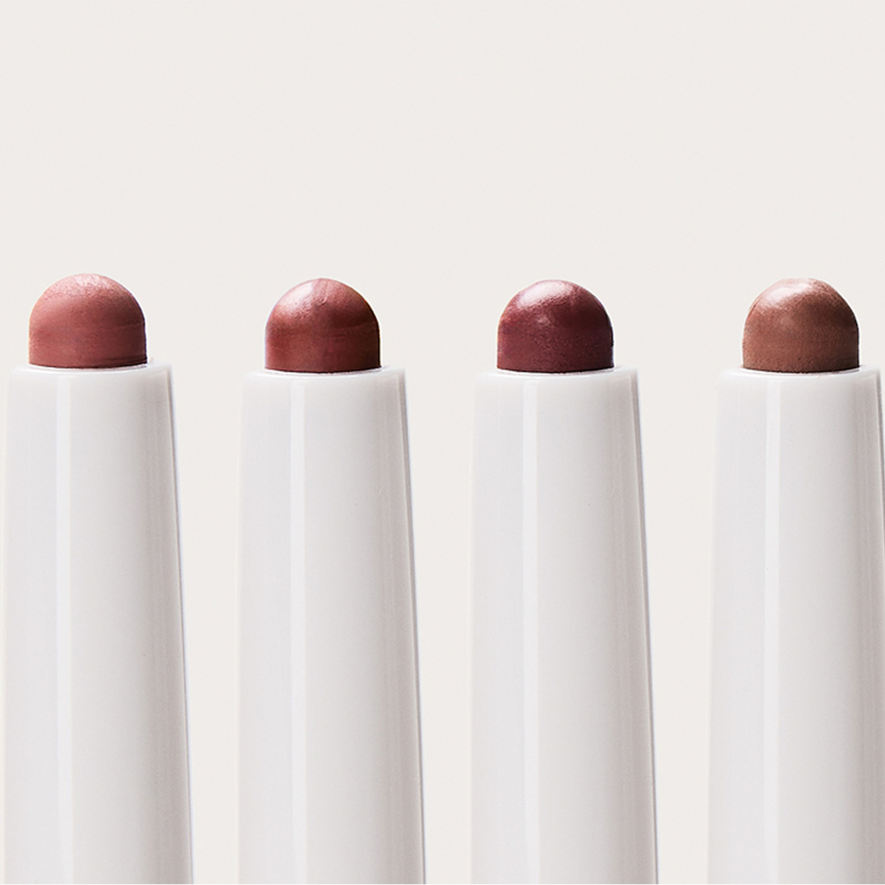 M.A.C lipsticks and lip tints in burgundy, terracotta and plum shades displayed with glass beakers and liquid pigments