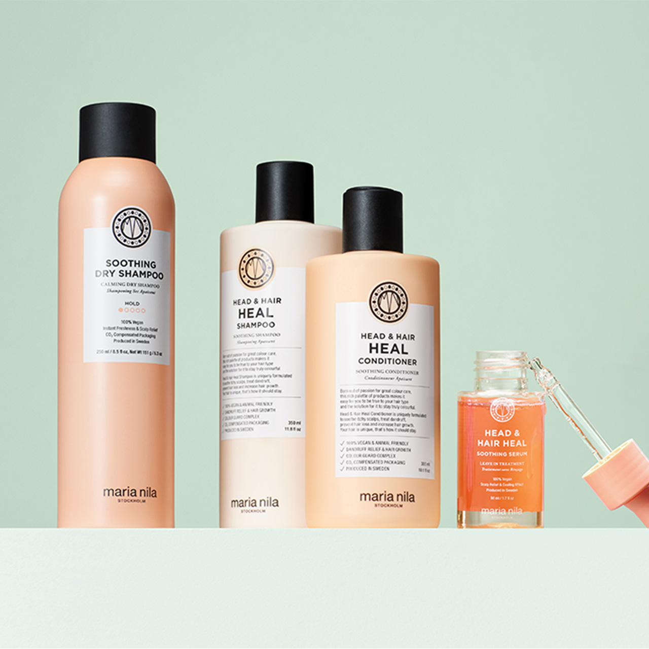Maria Nila Head & Hair Heal collection including dry shampoo, shampoo, conditioner and soothing serum on mint green background