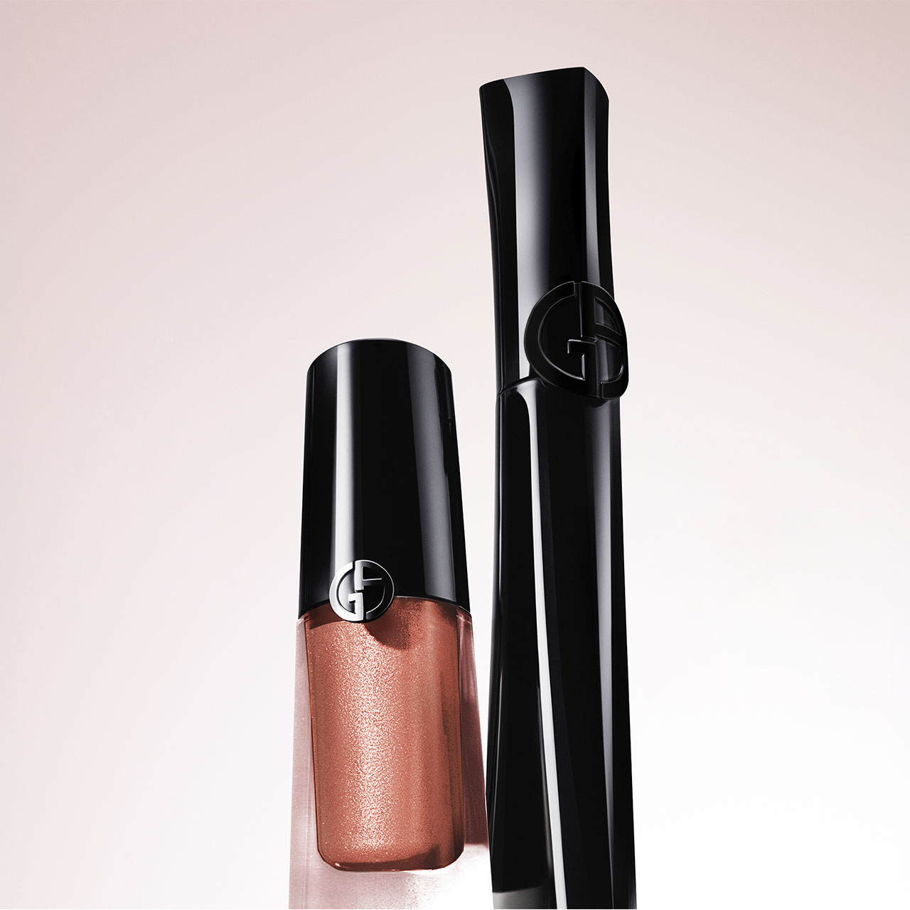 Armani liquid eyeshadow in copper tone with black applicator and cap displayed against pale pink background