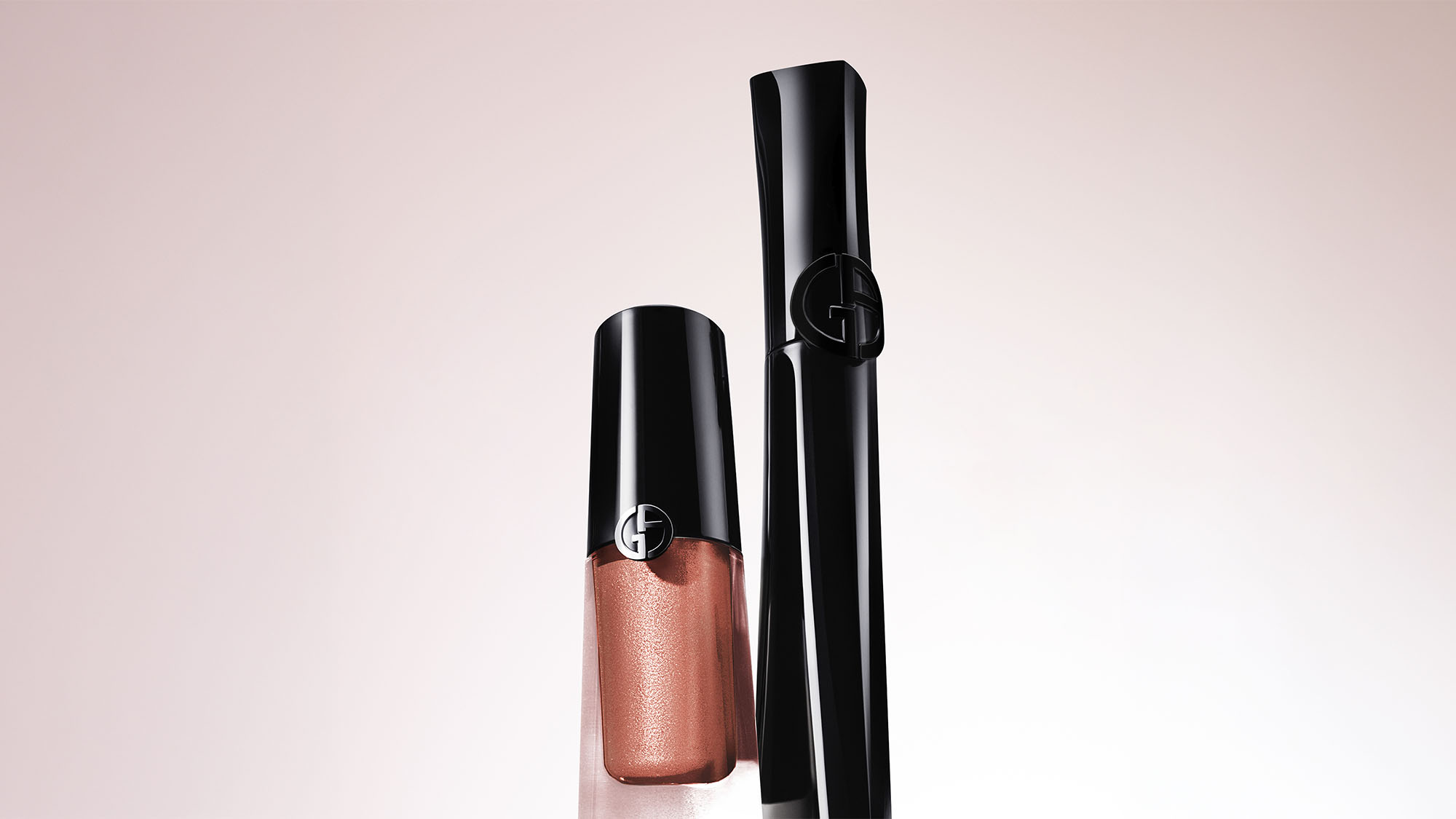 Armani liquid eyeshadow in copper tone with black applicator and cap displayed against pale pink background