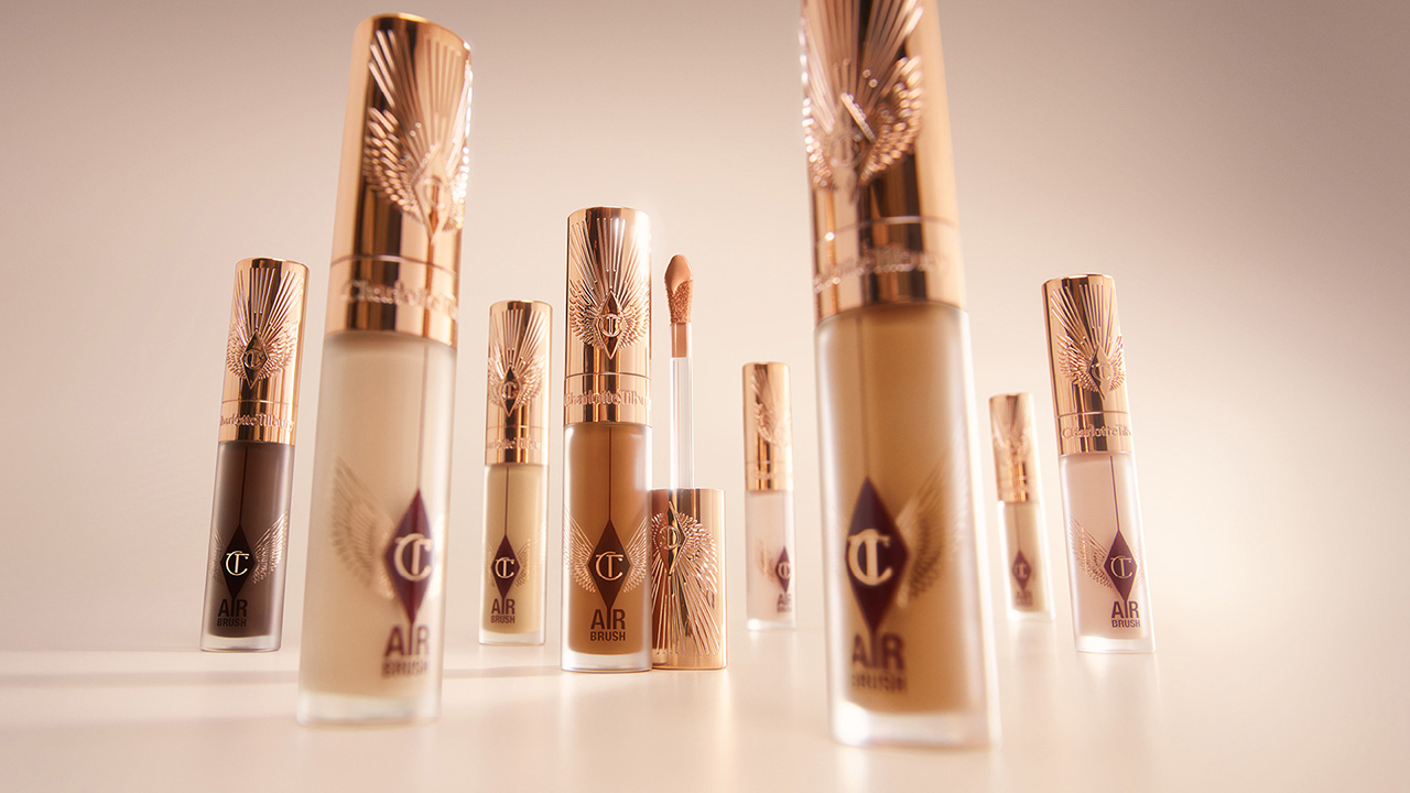 Elegant tubes of makeup with rose gold caps arranged on a light surface.