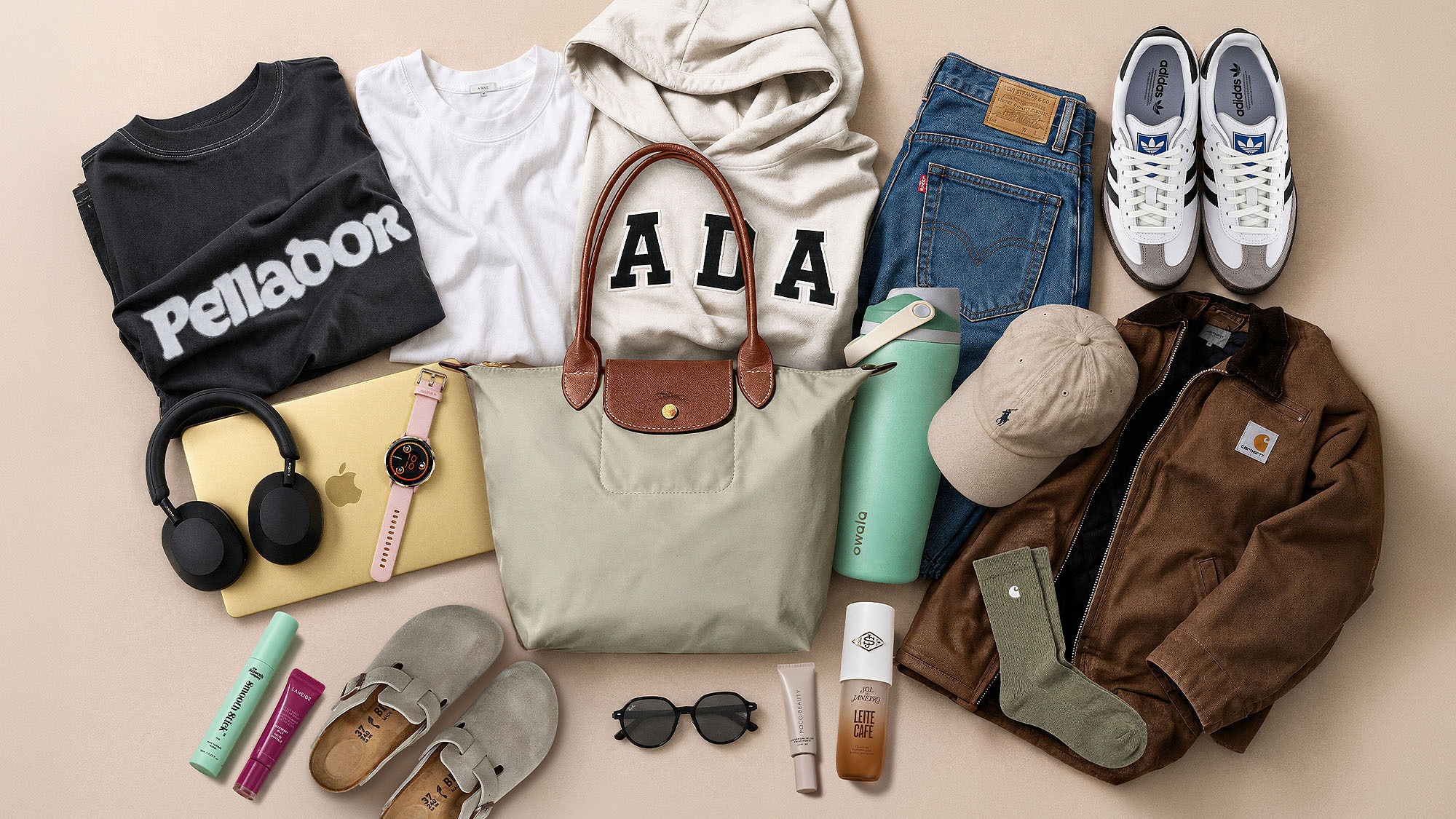 Flat lay of back to college essentials including t-shirts, jeans, trainers, handbag, watch, headphones, jacket and accessories