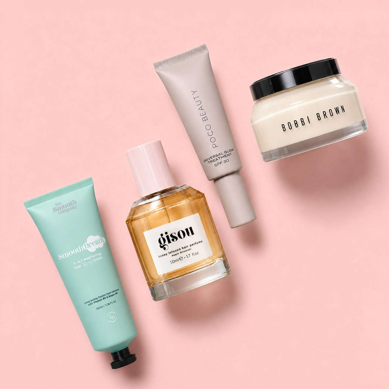 Collection of luxury beauty products including Bobbi Brown moisturiser, Gisou hair serum, and Poo~C sunscreen on pink background