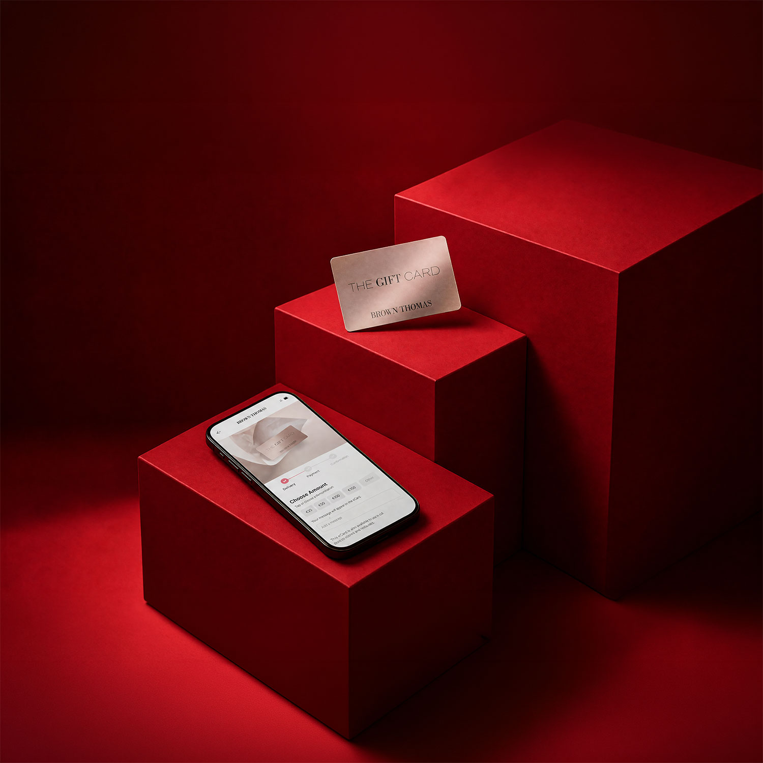Brown Thomas gift card and mobile phone displaying gift card purchase on red geometric display blocks