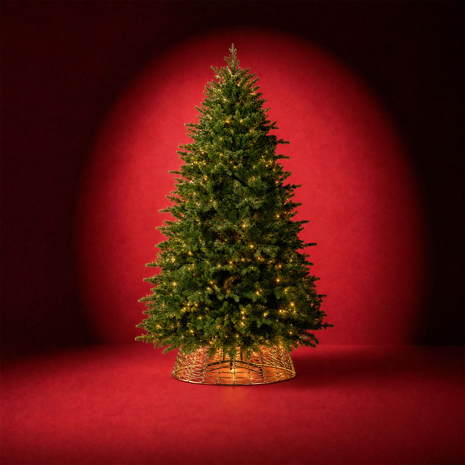 Pre-lit Christmas tree with warm golden lights and green foliage in a decorative gold basket stand