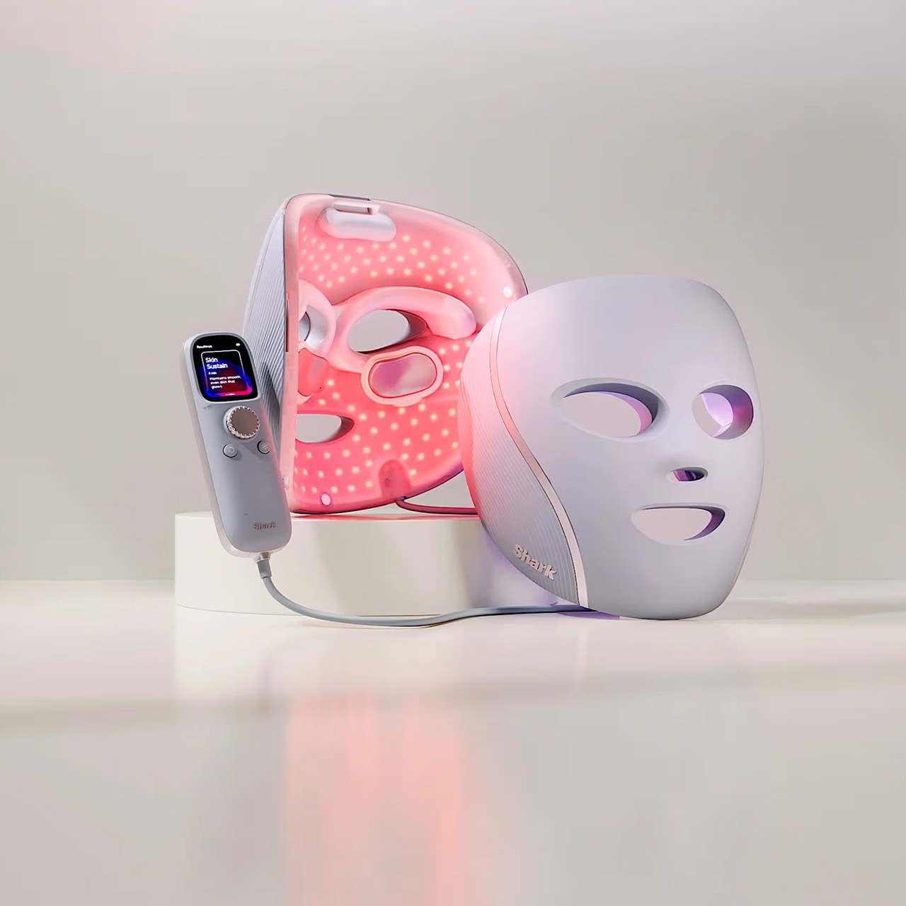 LED light therapy mask in white and pink LED light therapy device with handheld control unit