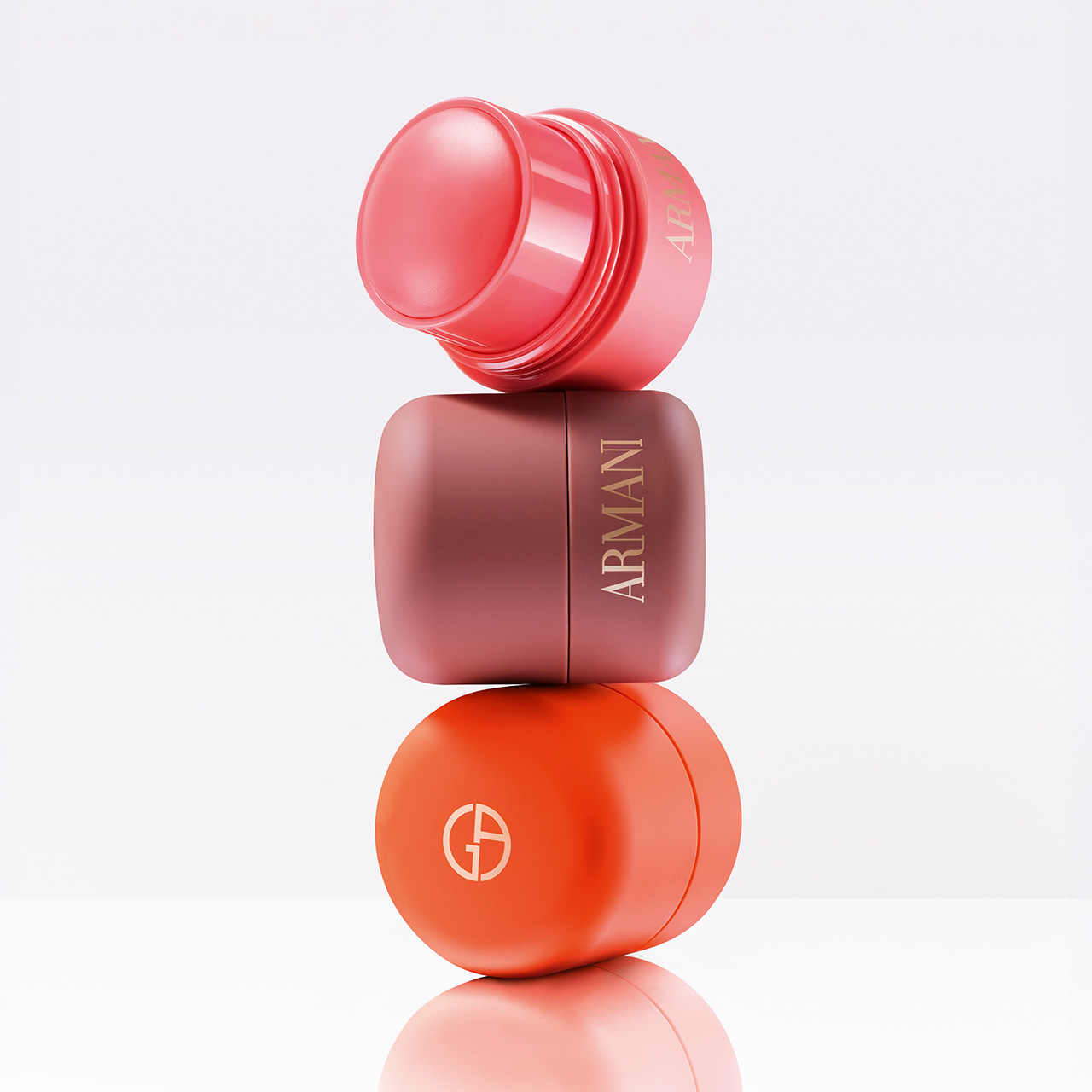 Three stacked Armani Beauty blush products in pink, mauve, and coral colours against neutral background