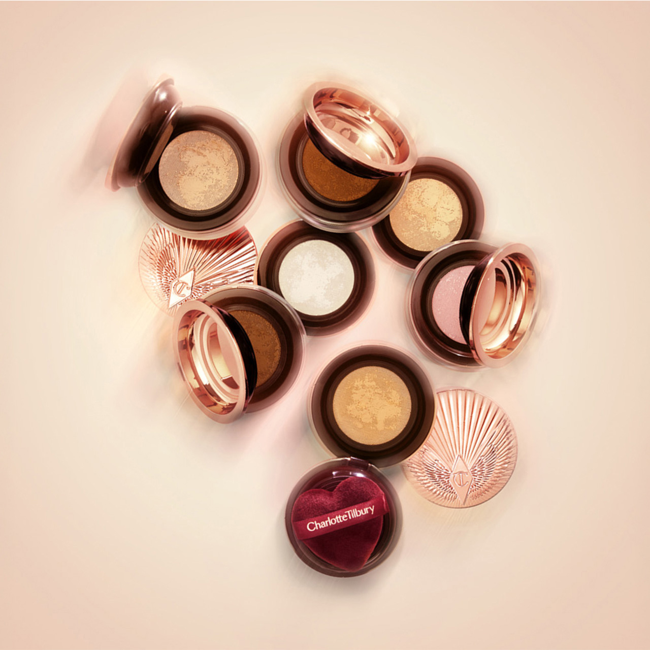 Charlotte Tilbury Airbrush Flawless Loose Powder in multiple shades with gold and rose-gold compacts arranged in circle