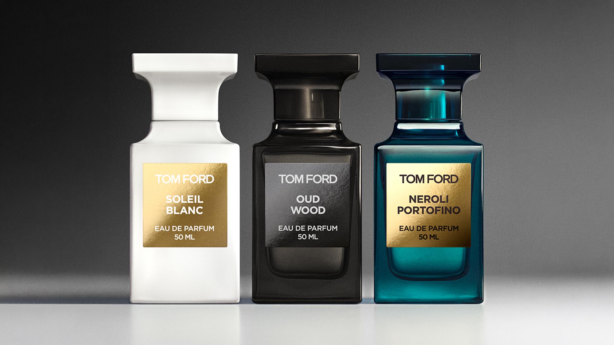 Three Tom Ford Private Blend eau de parfum bottles: white Soleil Blanc, black Oud Wood, and teal Neroli Portofino, 50ml each