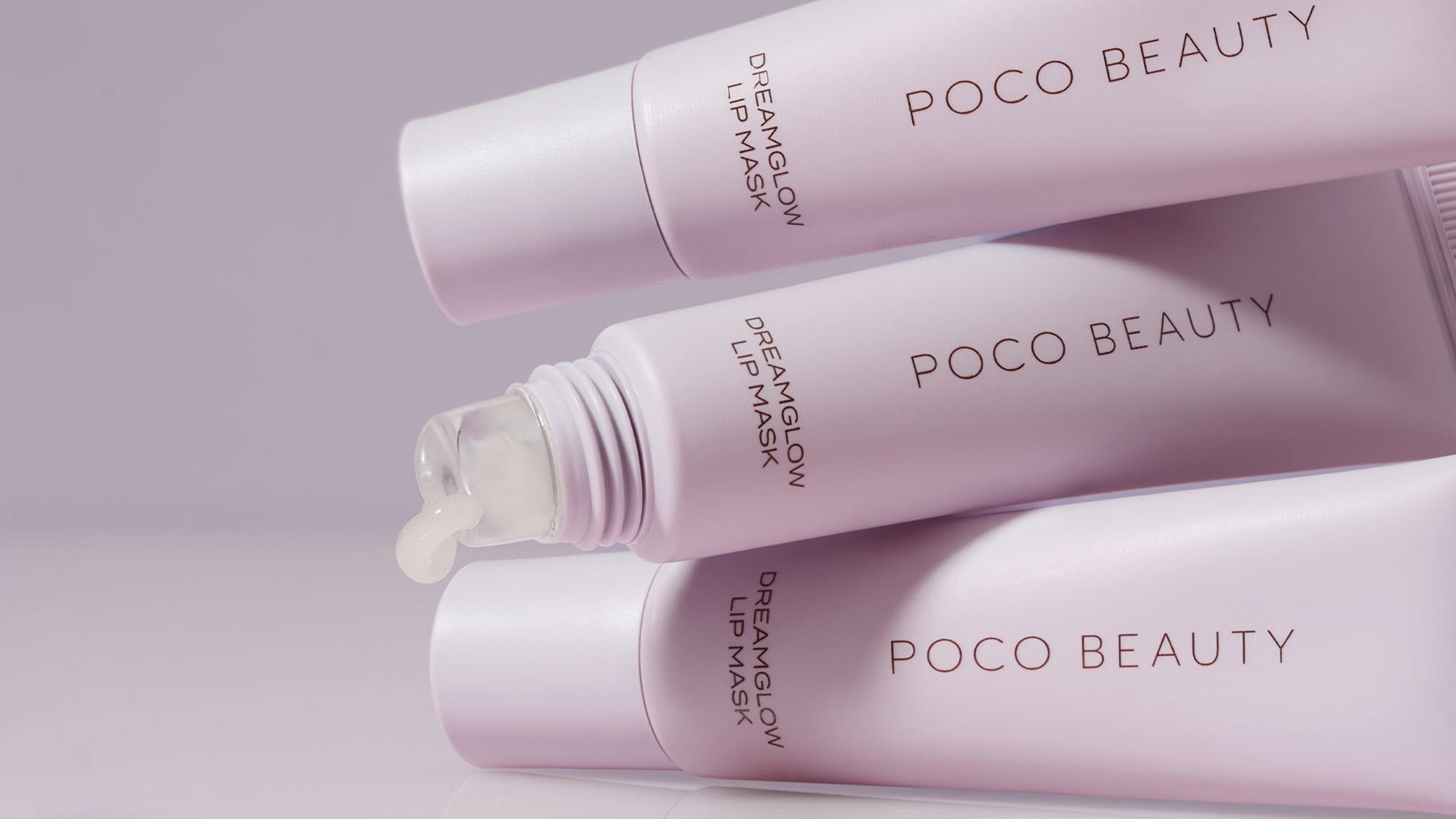 Three pink Poco Beauty Dream Glow lip mask bottles displayed on pale background with product textures visible