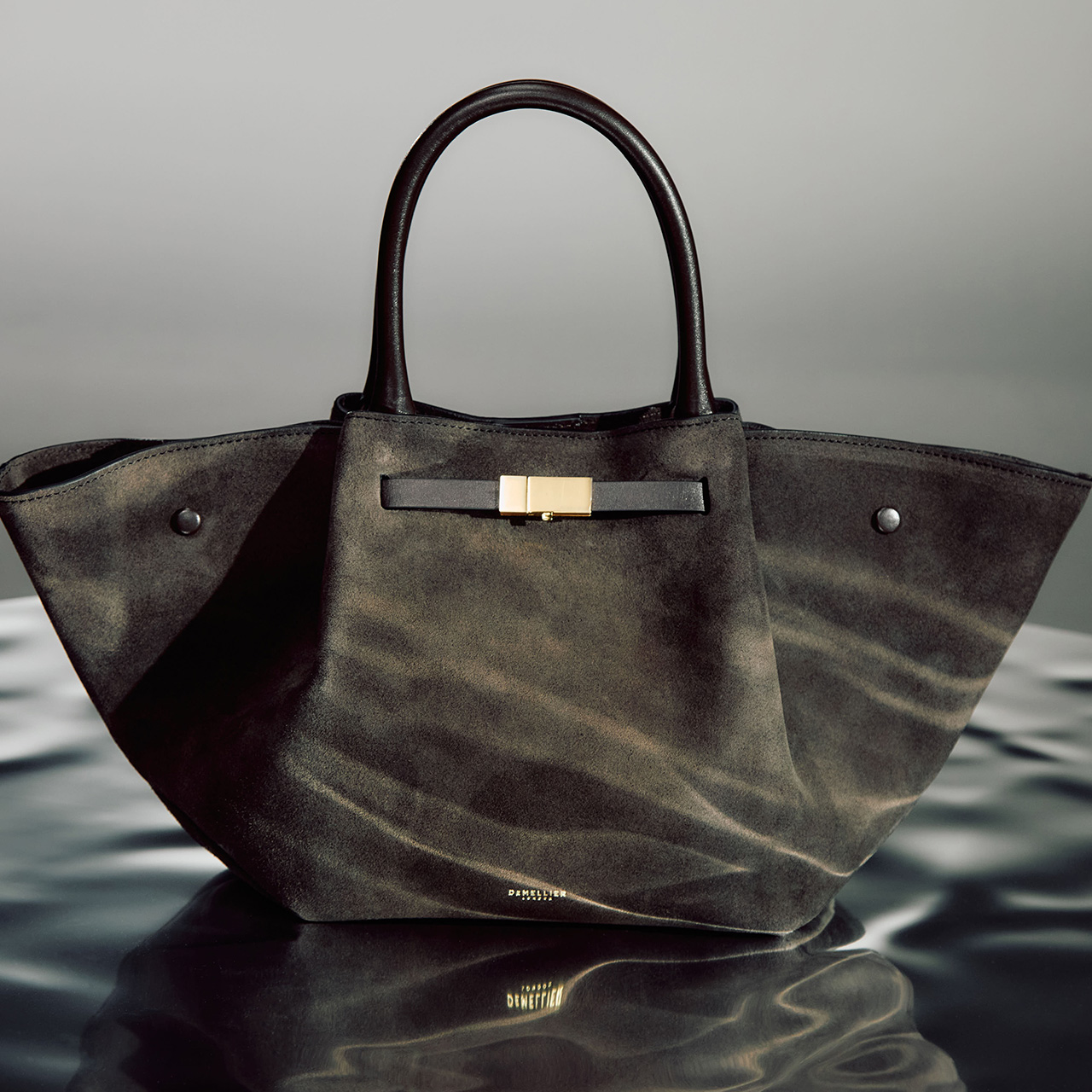 Olive green suede tote bag with gold-toned hardware detail and dual leather handles