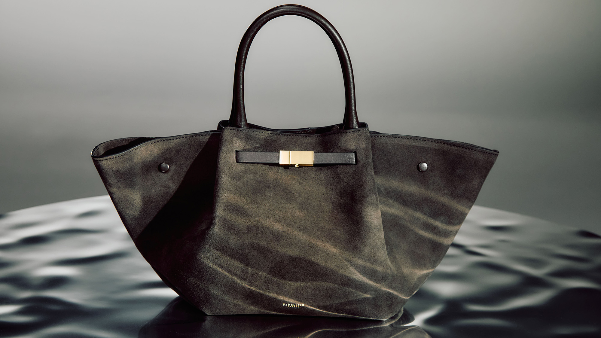 Olive green suede tote bag with gold-toned hardware detail and dual leather handles