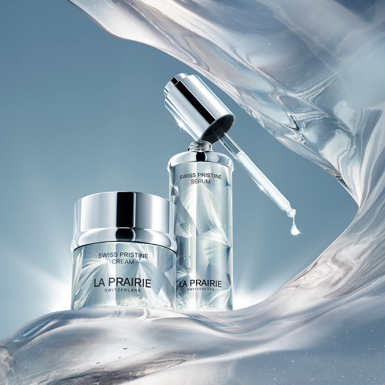La Prairie Swiss Pristine serum and cream displayed against crystalline ice formations and blue sky background
