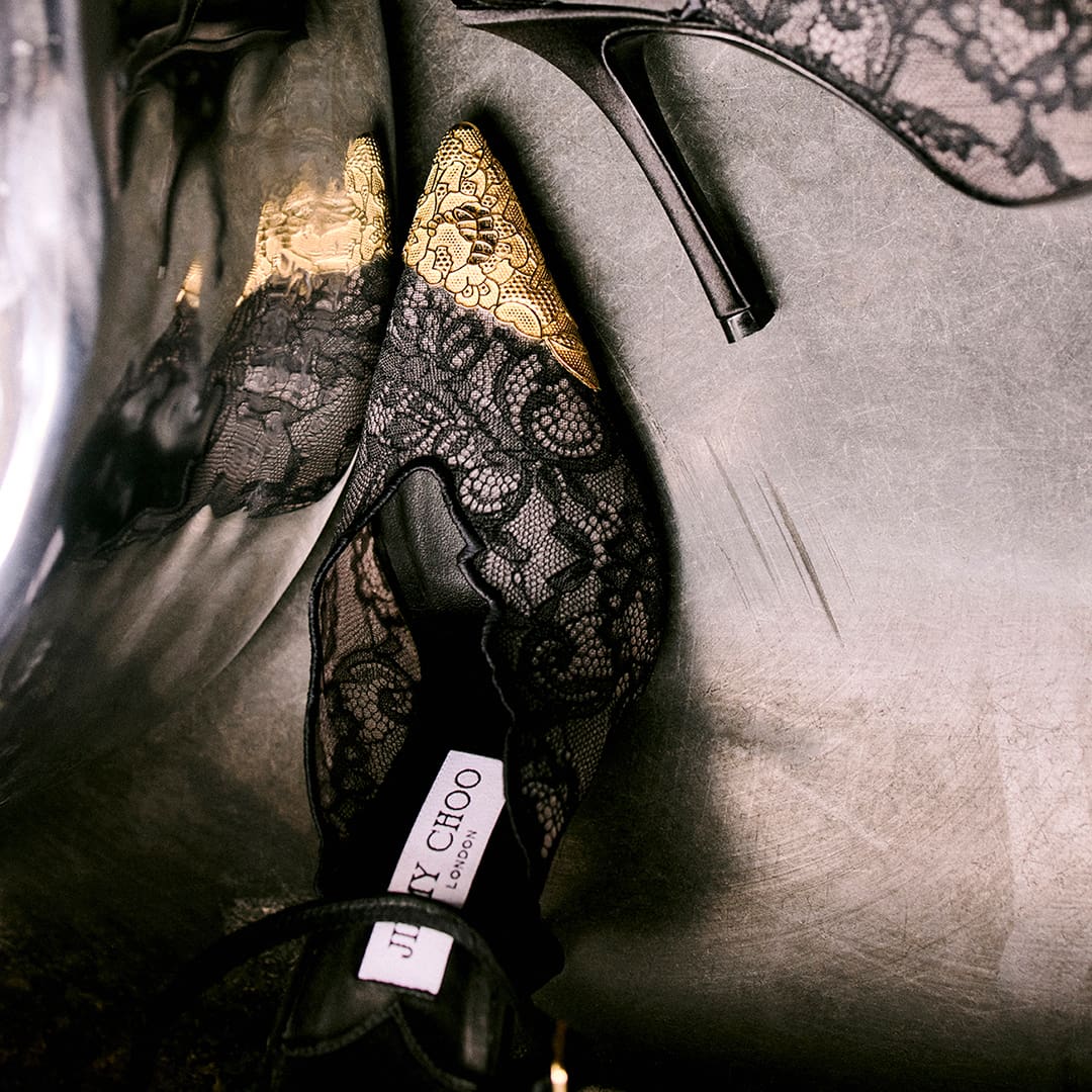 Black lace shoe with Jimmy Choo label visible on neutral background