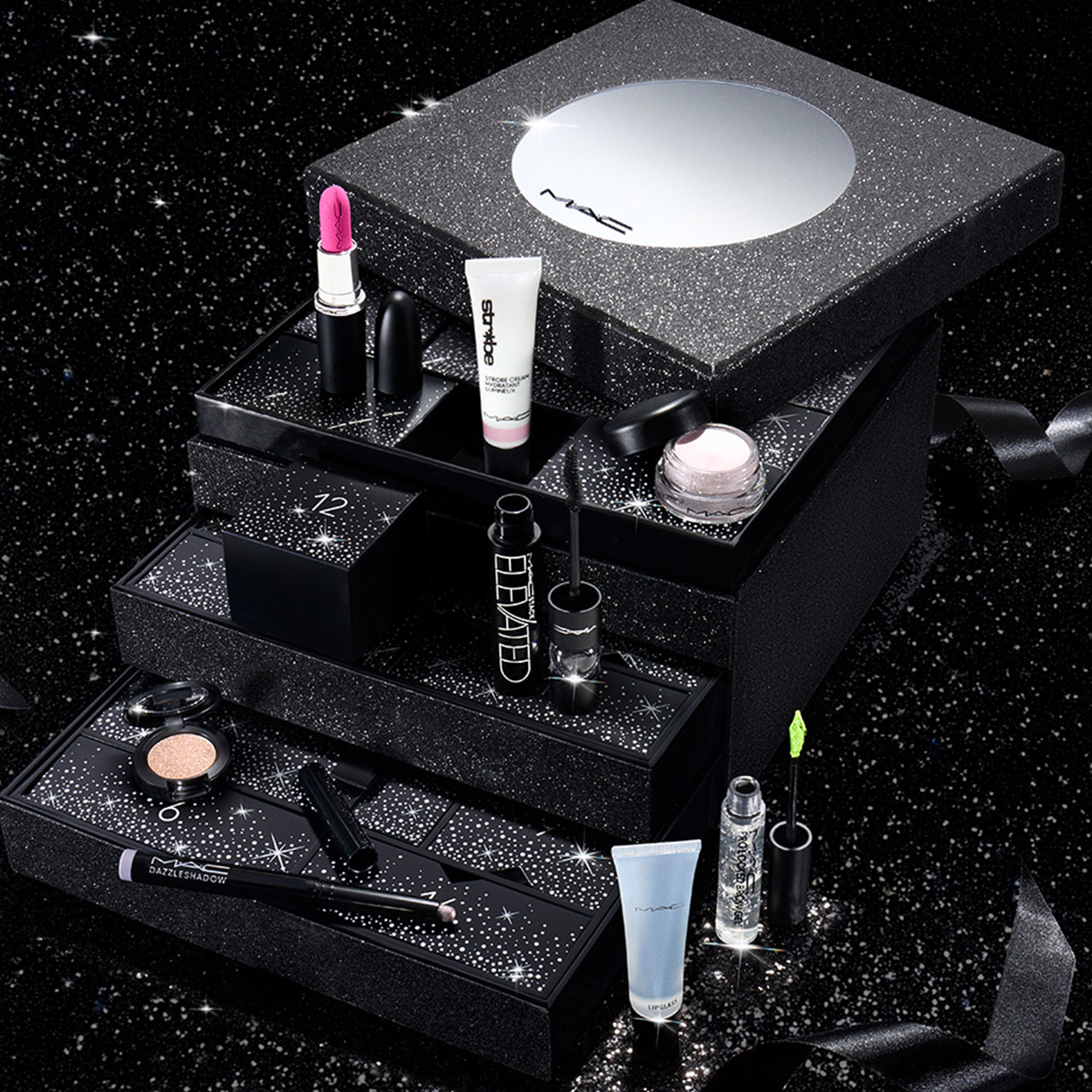 M.A.C beauty advent calendar with tiered black glitter boxes displaying lipstick, eyeshadow, mascara and skincare products.