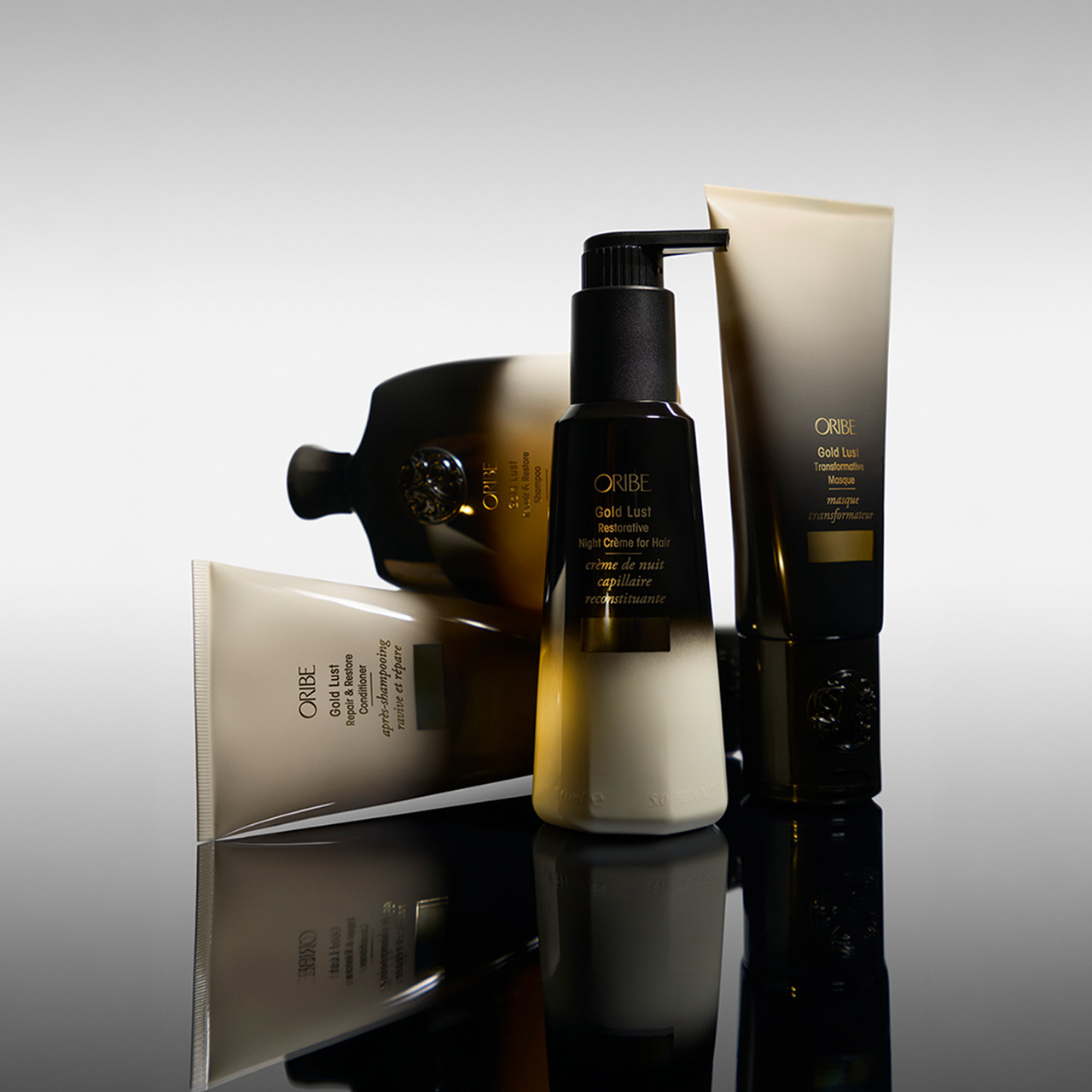 Oribe Gold Lust hair care collection including shampoo, conditioner, night cream and treatment products in black and gold bottles
