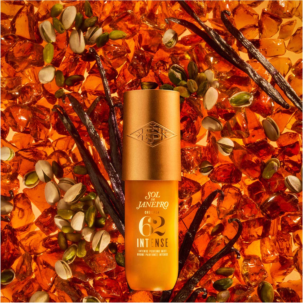 Sol de Janeiro Coco 62 Intense perfume mist displayed on warm orange and amber background with vanilla pods and black vanilla beans
